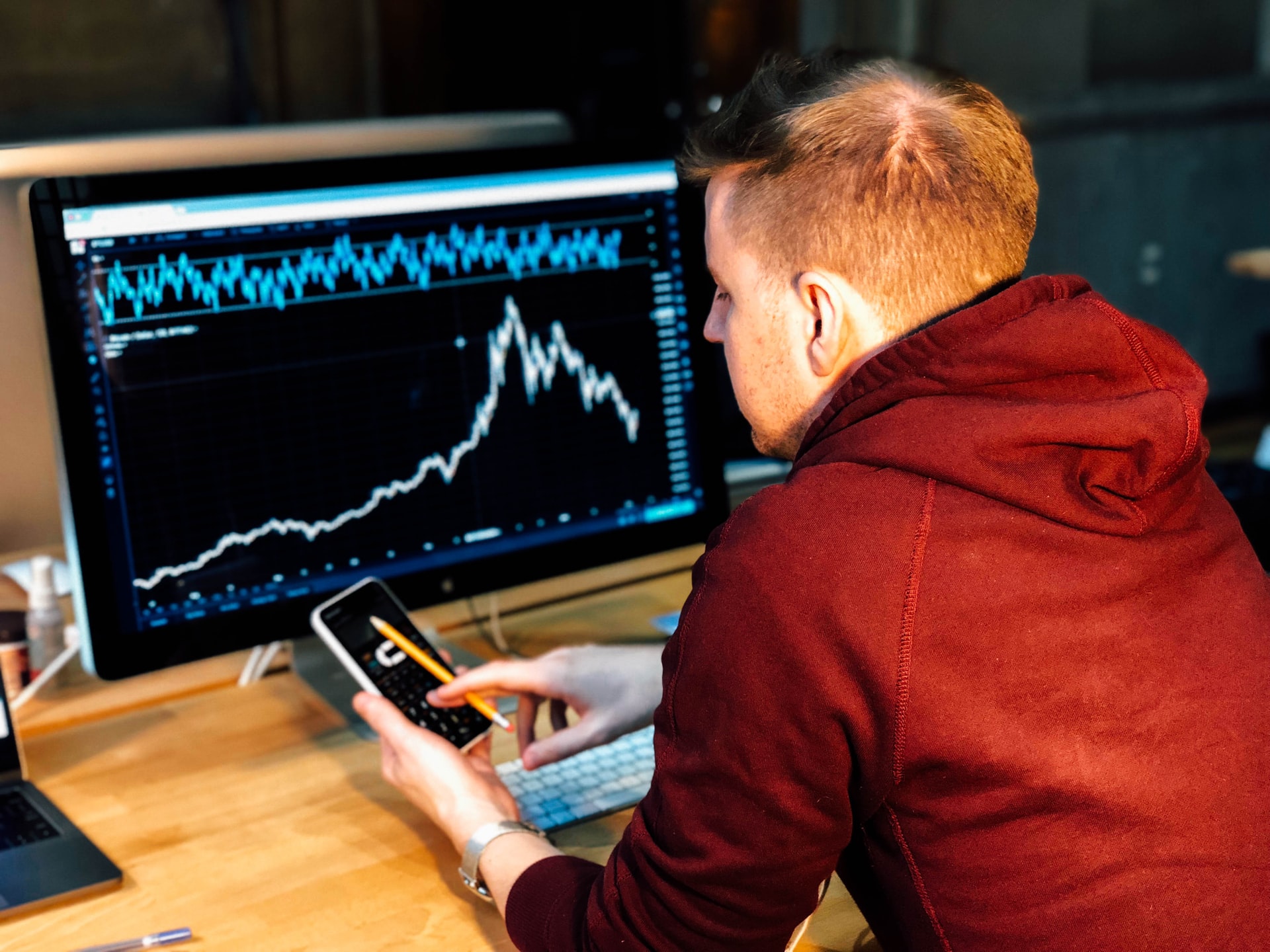 A man looking at a computer screen displaying a graph.