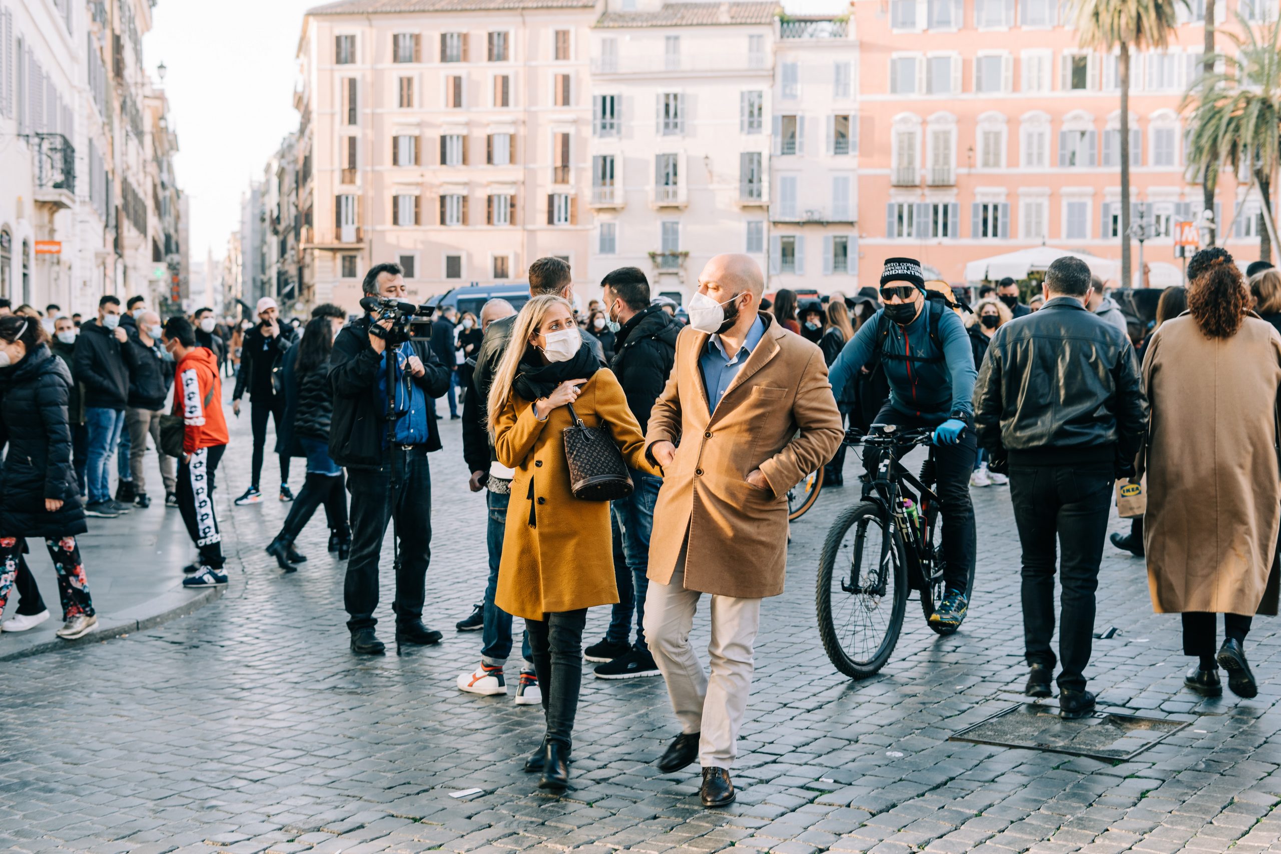 Busy square during the pandemic with people wearing PPE