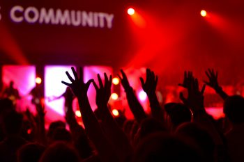 People raising their hands at a community event..